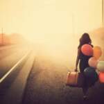 woman-walking-along-the-road-with-suitcase-and-balloons-e1452236779883