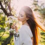 Girl-hair-in-the-wind-sun-rays-spring-white-flowers_1920x1200