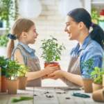 cute-child-girl-helping-her-mother-to-care-plants-mom-her-daughter-engaging-gardening-near-window-home-happy-family-109735387