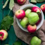 green-and-red-apples-in-a-bowl-and-on-a-wooden-table