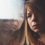 a-sad-woman-looking-out-of-a-window